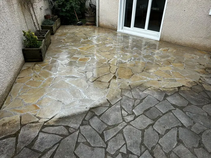 Terrasse en pierres dont la moitié nettoyée contraste avec la moitié encore grise